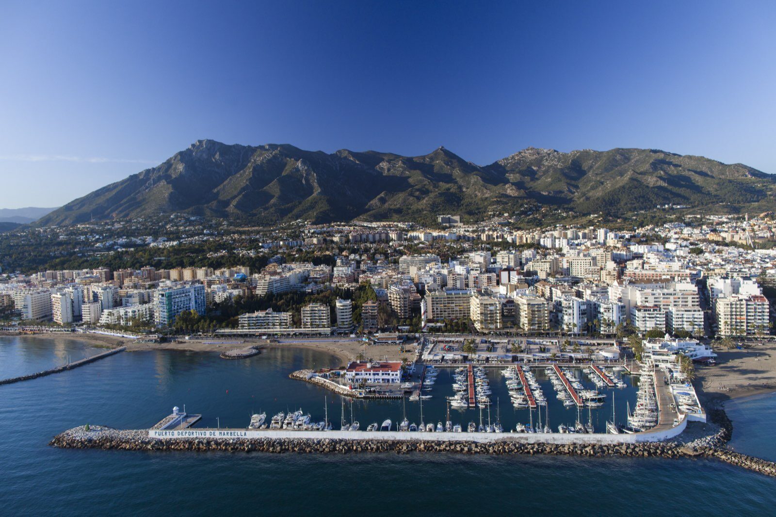 Marbella's marina, old town and the Sierra Blanca mountains from the air
